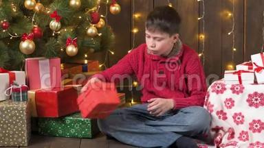 男孩坐在室内，靠近装饰的<strong>圣诞</strong>树，<strong>灯光</strong>和礼物-<strong>圣诞</strong>快乐和节日快乐！